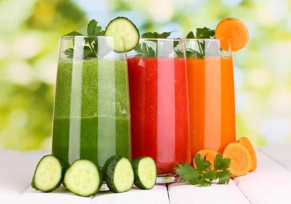 Jugos de verduras frescas sobre mesa de madera, sobre fondo verde — Foto de Stock