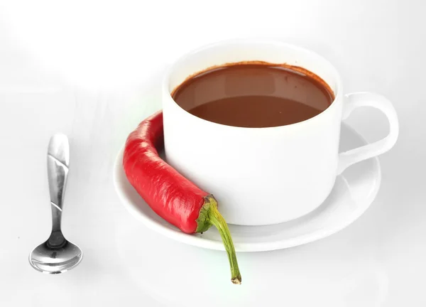 White cup with hot chocolate and chili pepper isolated on white Royalty Free Stock Photos