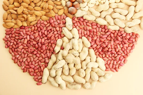 Assortiment van smakelijke noten, op beige achtergrond — Stockfoto