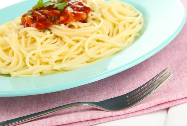 Włoskie spaghetti w talerzu na drewnianym stole — Zdjęcie stockowe