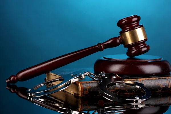 Gavel, handcuffs and book on law on blue background — Stock Photo, Image