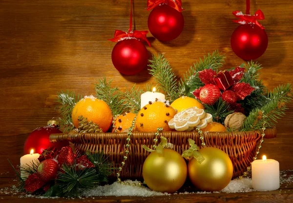 Composición navideña en cesta con naranjas y abeto, sobre fondo de madera — Foto de Stock
