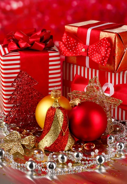 Рождественские украшения и подарки на красном фоне — стоковое фото