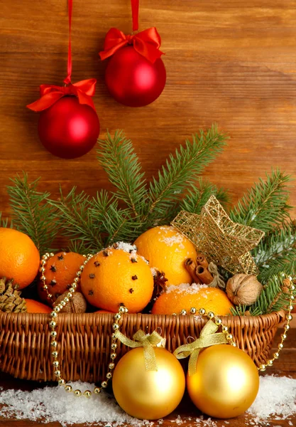 Christmas composition in basket with oranges and fir tree, on wooden background Stock Photo