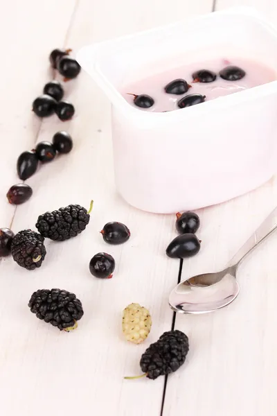 Yogurt with berries on wooden background — Stock Photo, Image