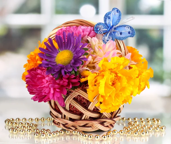 Piękny bukiet kwiatów jasny w mały koszyk z papieru Uwaga na stół biały na tle okna — Zdjęcie stockowe