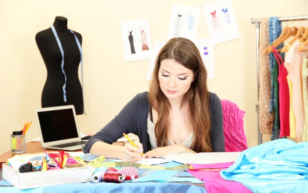 Beautiful young dressmaker in workroom — Stock Photo, Image