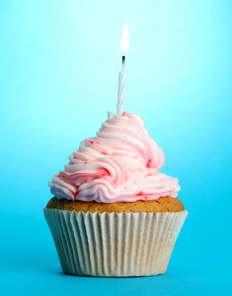 Välsmakande födelsedag cupcake med ljus, på blå bakgrund — Stockfoto