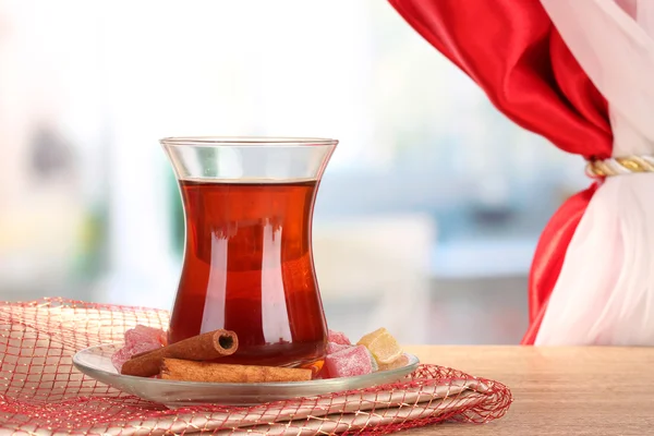 Glass of Turkish tea and rahat lokum, on wooden table — Stock Photo, Image