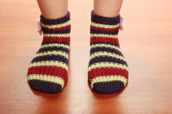 Piernas femeninas en calcetines a rayas en suelo laminado —  Fotos de Stock