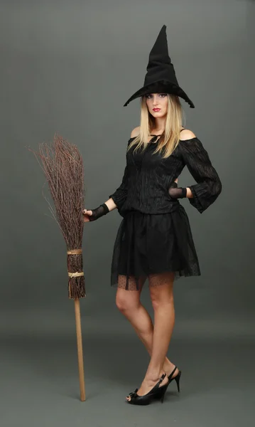 Halloween czarownica z miotły na szarym tle — Zdjęcie stockowe