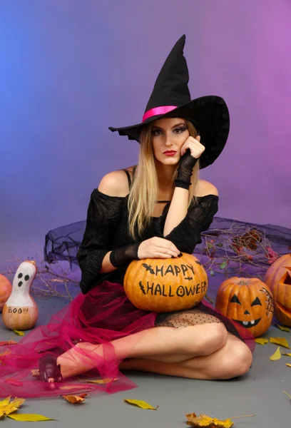 Halloween witch holding pumpkin on color background — Stock Photo, Image