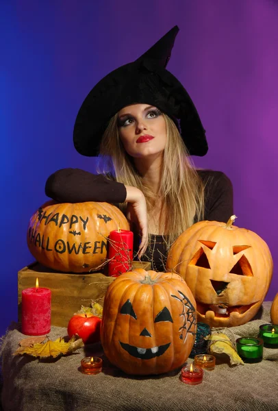 Halloween witch with pumpkins on color background — Stock Photo, Image