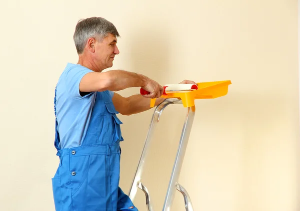 Pintor masculino pinta la pared en la habitación de cerca —  Fotos de Stock