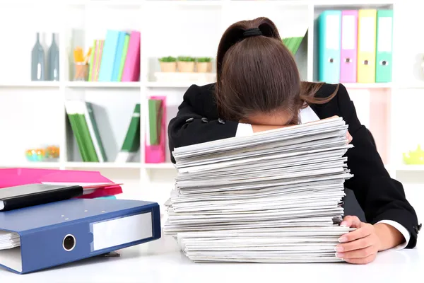 Tired business woman with documents in her workplace — Stock Photo, Image