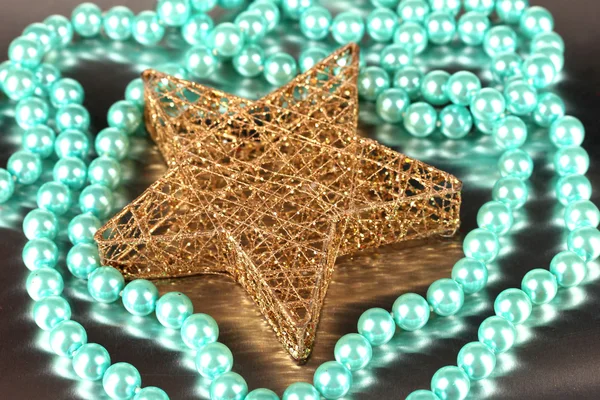Christmas star and bead on gray background — Stock Photo, Image