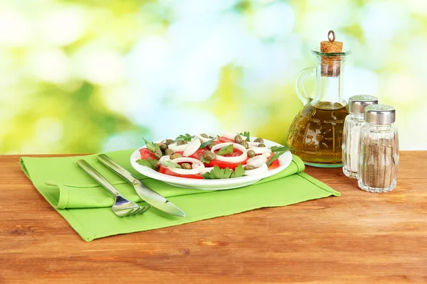 Salat mit Kapern im Teller auf hellgrünem Hintergrund — Stockfoto