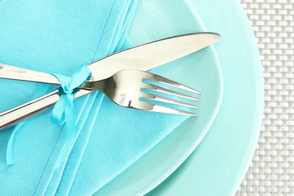 Platos vacíos azules con tenedor y cuchillo sobre un mantel gris —  Fotos de Stock