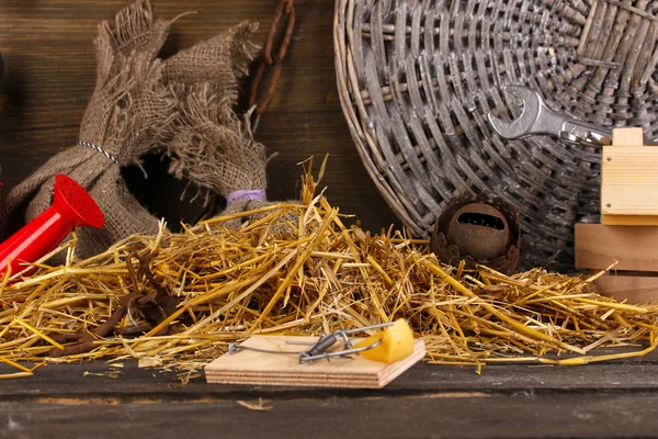Trappola per topi con un pezzo di formaggio in fienile su sfondo di legno — Foto Stock