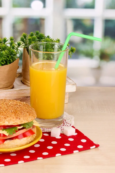 Smakelijk sandwich op kleurplaat op houten tafel op achtergrond van venster — Stockfoto