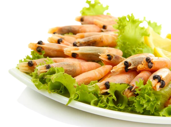 Boiled shrimps with lemon and lettuce leaves on plate, isolated on white — Stock Photo, Image