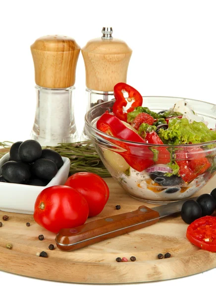 Fresh greek salad in glass bowl surrounded by ingredients for cooking isolated on white — Stock Photo, Image