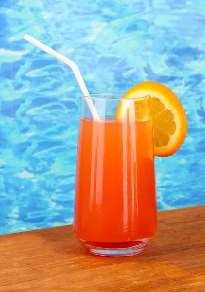 Glass of orange cocktail on blue background — Stock Photo, Image