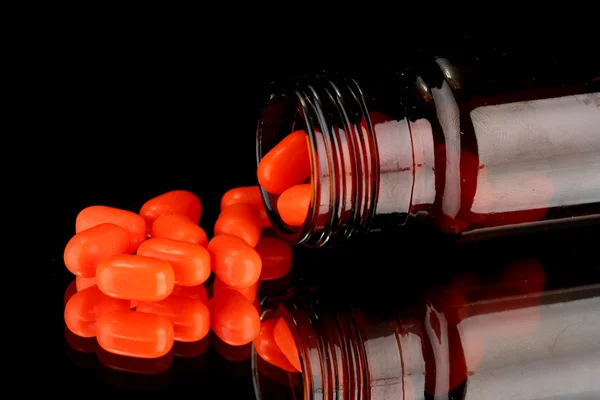 Pills in bottle isolated on black — Stock Photo, Image
