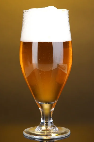 Glass of beer on yellow background — Stock Photo, Image