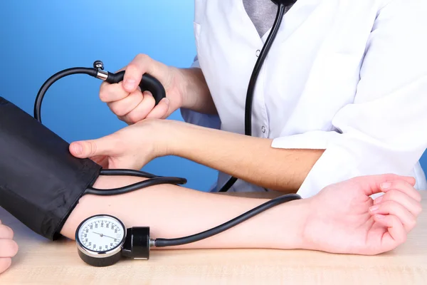 Medición de la presión arterial sobre fondo azul —  Fotos de Stock