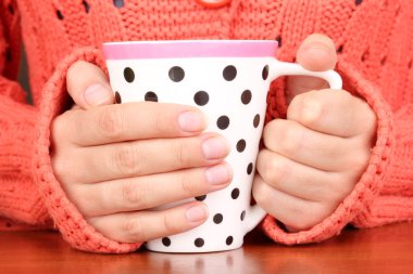 yakın çekim sıcak bir fincan tutan eller iç