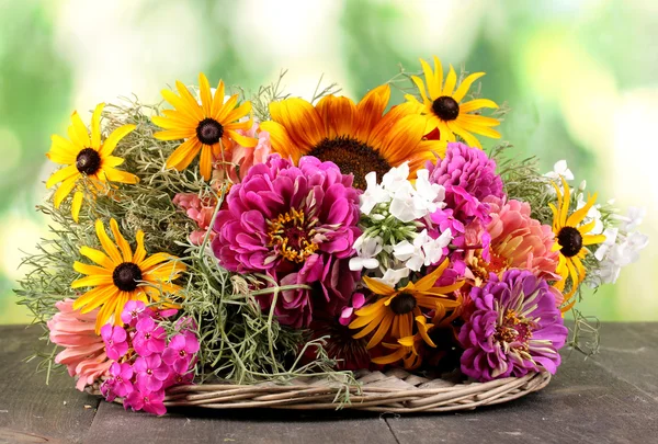 Beautiful bouquet of bright flowers on wooden table on nature background — Stock Photo, Image