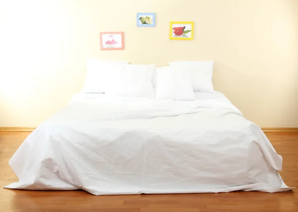 Пустая кровать с подушками и простынями в спальне — стоковое фото