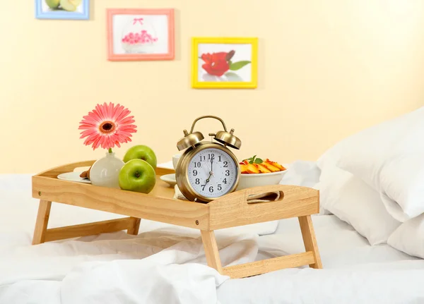 Träbricka med lätt frukost på sängen — Stockfoto