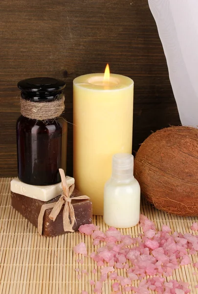 Fles met aromatische oliën met accessoires voor ontspanning close-up op houten tafel op houten achtergrond — Stockfoto