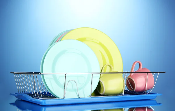 Цветные тарелки в стойке на голубом фоне — стоковое фото