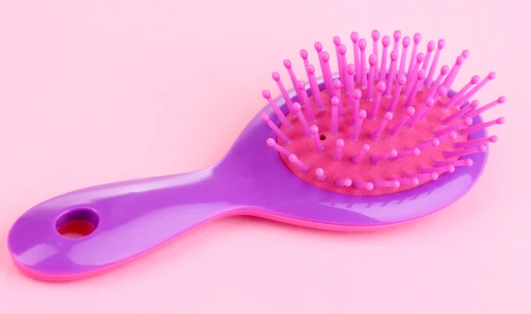 Brosse à cheveux pourpre sur fond rose — Photo