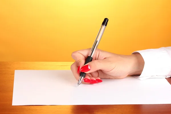 Handen schrijven op papier op blauwe achtergrond — Stockfoto