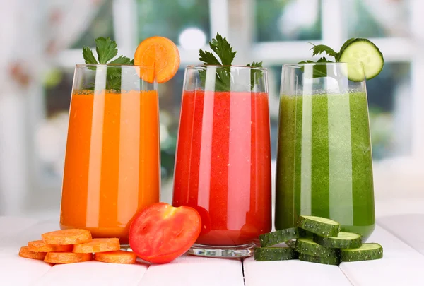 Jugos de verduras frescas en la mesa de madera, en el fondo de la ventana — Foto de Stock