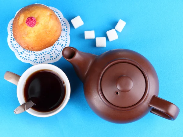 Top view of cup of tea and teapot on blue tablecloths — Stock Photo, Image