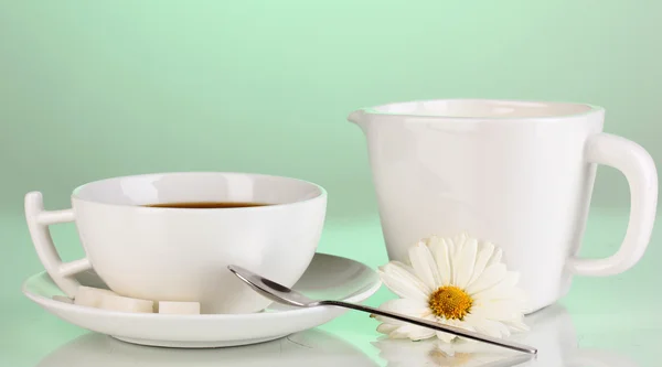 Чашка міцної кави та солодкого крему на зеленому фоні — стокове фото