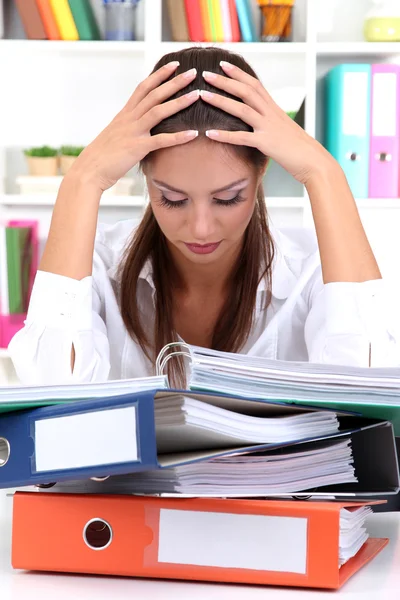 Femme d'affaires fatiguée avec des documents dans son lieu de travail — Photo