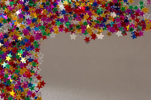 Estrelas confetti no fundo cinza — Fotografia de Stock