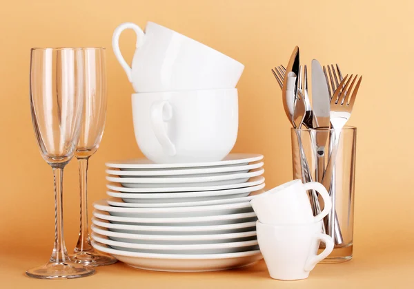 Bej renkli arka plan üzerinde beyaz bulaşıkları temizle — Stok fotoğraf