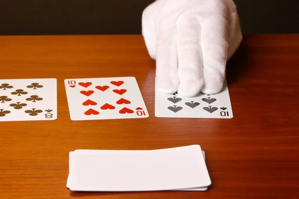 Karty i ręka na brązowym tle — Zdjęcie stockowe