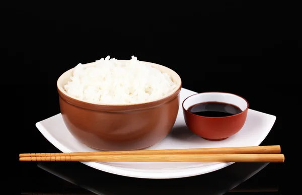 Cuenco de arroz y palillos en plato aislado en negro —  Fotos de Stock