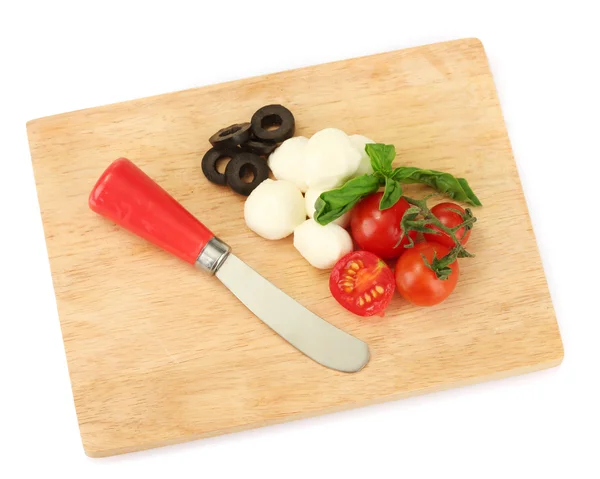 Queso mozzarella con verduras en la tabla de cortar aislado en blanco — Foto de Stock