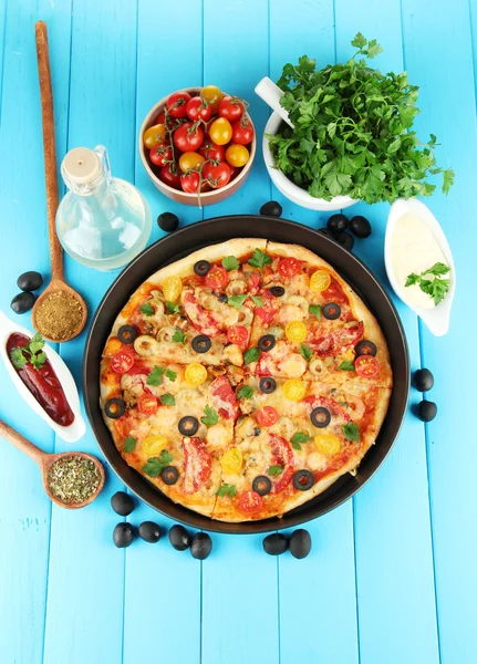 Πολύχρωμο σύνθεση νόστιμη πίτσα, λαχανικά και μπαχαρικά σε μπλε φόντο ξύλινη κοντινό πλάνο — Φωτογραφία Αρχείου