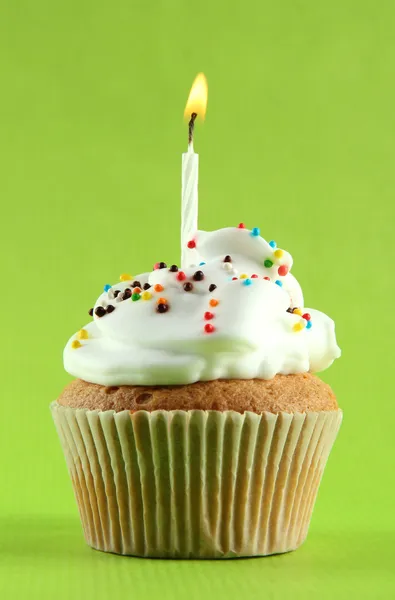 Smakelijke verjaardag cupcake met kaars, op groene achtergrond — Stockfoto