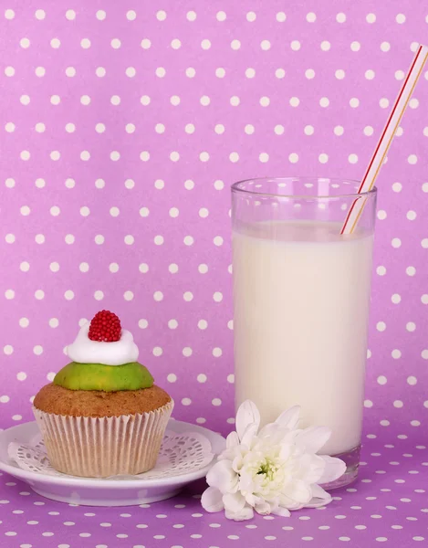 紫の水玉の背景にケーキと新鮮な新しいミルクのガラス — ストック写真